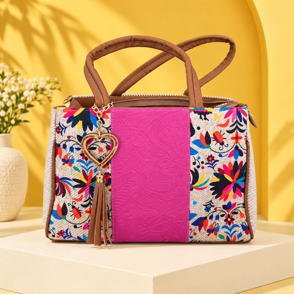 Hot pink floral VidaFeliz embossed jute satchel on a bright yellow studio backdrop.