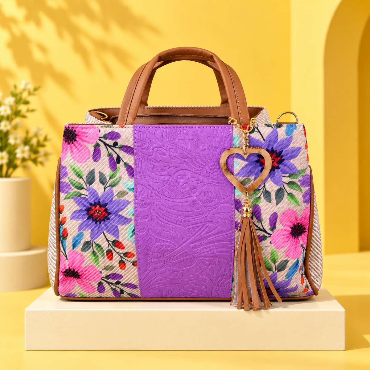 Purple floral VidaFeliz embossed jute satchel on a bright yellow studio backdrop.